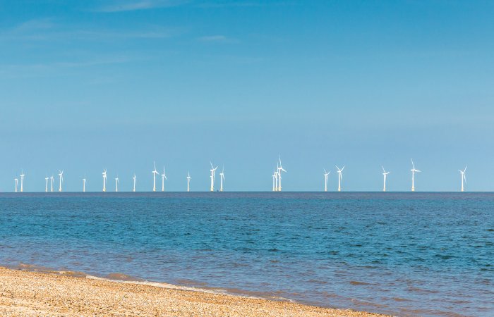 Offshore wind farm visible from a beach